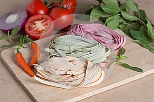 Three pieces of colorful italian fettuccine pasta with basil, to