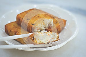 Three pieces of deep fried carrot cake with real carrot bits inside