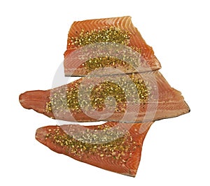 Three pieces of fresh raw rainbow trout with spices