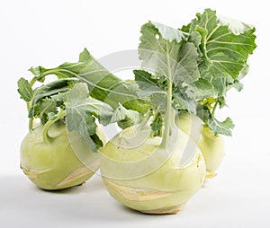 Three pieces of kohlrabi vegetable isolated on yellow simple background with copy space