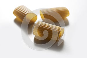 Three pieces of macaroni wholemeal pasta isolated on white background