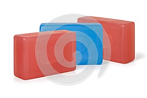 Three pieces of red and blue toilet soap on a white background. Full depth of field.