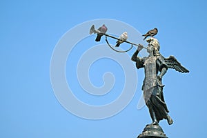 Three Pigeons Relaxing on the Historic Statue of Angel of the Fame on the Fountain at Plaza Mayor in Lima, Peru