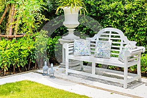 A three pillow white bench and cement pots with duck dolls under