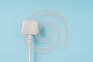 Three pin plug on light blue background with a copy space