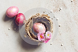 Three pink Easter eggs with golden spots in the nest