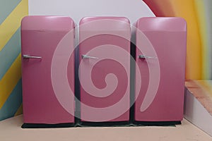 Three pink fridges in a row