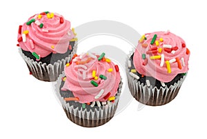 Three pink frosted chocolate cupcakes isolated on a white background