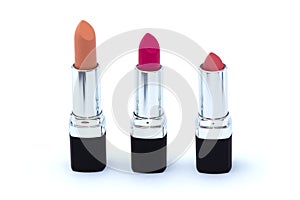 Three pink lipsticks in black case isolated on white
