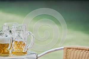 Three pitchers of beer on a half-drunk table with a greenish background of water from the Venice canal