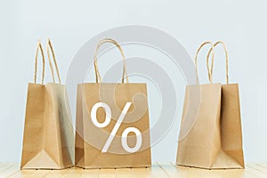 Three plain paper bags with percentage sign. Packages delivery and sale