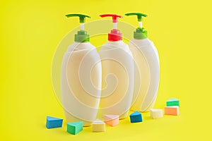 Three plastic bottles with dispenser on yellow background