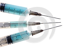 Three plastic disposable syringes with a metal needles with blue