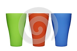 Three plastic multi-colored glasses isolated on a white background. Plastic glass of various color isolated on white background