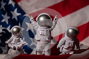 Three Plastic toys figure astronaut on American flag background Copy space. 50th Anniversary of USA Landing on The Moon