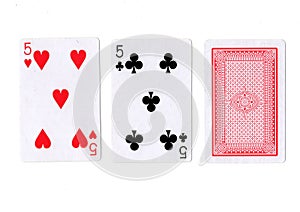 Three playing cards with a pair of fives revealed.