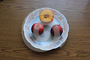 Three plums: one is slightly cut