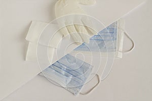 Three ply structure,single use hygenic face mask,sterile gauze pads and gloves on the white photo
