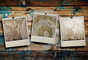 Three Polaroid hanging on wooden background