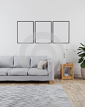 Three poster frames mockup in modern and minimalist interior of living room with sofa, white wall and wooden floor with grey