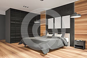 Three posters on stylish black stone detail of wall in wooden bedroom