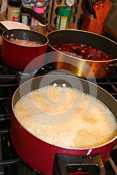 Three pots on stove cooking food for dinner