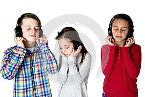 Three preteens listening to music with headphones eyes closed