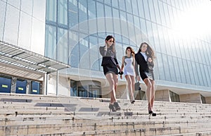 Three pretty businesswoman in front of a trade building