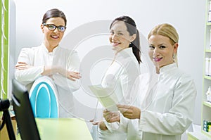 Three pretty female pharmacists at work posing