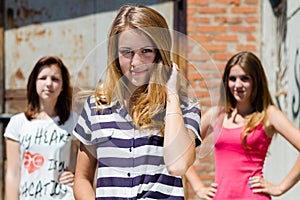 Three pretty happy young women have fun in city outdoors