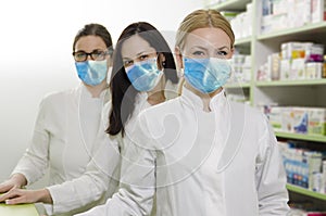 Three professional female pharmacists with masks