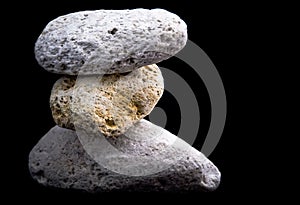 Three pumice stones on black photo