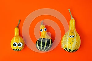 Three pumpkins of different sizes with toy eyes