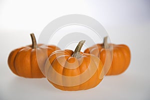 Three pumpkins on white.