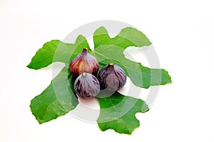 Three purple figs and a green leaf