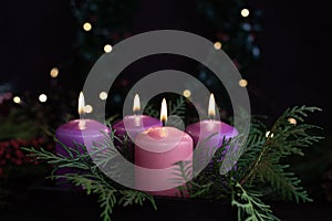 Three purple and one pink advent candles in Christmas eve