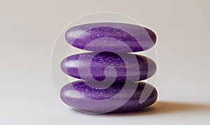 Three purple stones stacked on top of each other, isolated on a white background