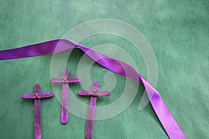 Three purple wooden cross in green background. Holy week and lent season celebration concept.