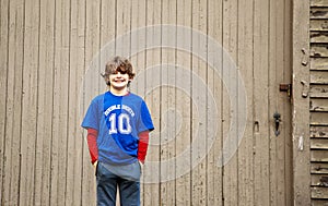 Three quarter length portrait of a 10 year old boy standing in front of a barn photo