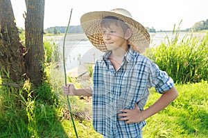 Three-quarter view portrait of relaxing angler teenage boy wearing plaid shirt and straw hat