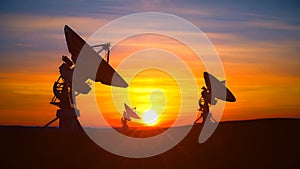 Three radio telescopes against scenic sunset exploring evening sky