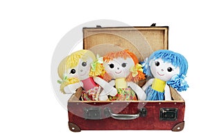 Three rag dolls in a vintage suitcase