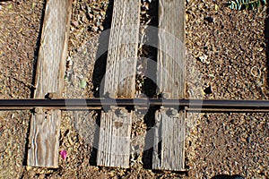 Three rails road ties with one rail weathered with bolts