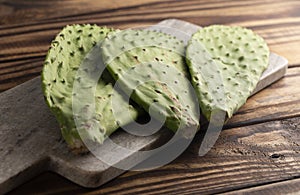 Three Raw Cactus Paddles on a Dark Wooden Table