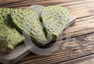 Three Raw Cactus Paddles on a Dark Wooden Table