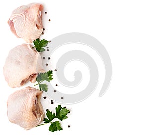 Three raw chicken shin with parsley leaves and pepper on a white. The view from the top.