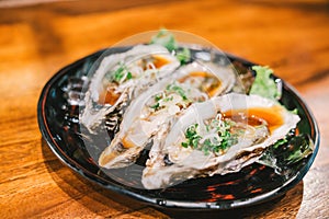 Three raw juicy oyster freshly opened and served on dish at Japanese restaurant. Fresh seafood famous menu