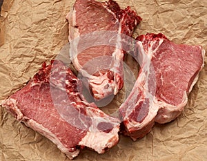 Three raw juicy pork slices of meat on the rib