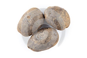 Three raw potatoes, unpeeled. Isolated on a white background
