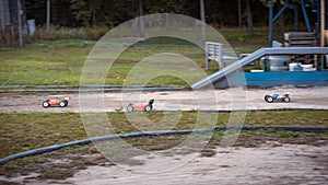 Three RC buggies racing on an outdoor offroad track